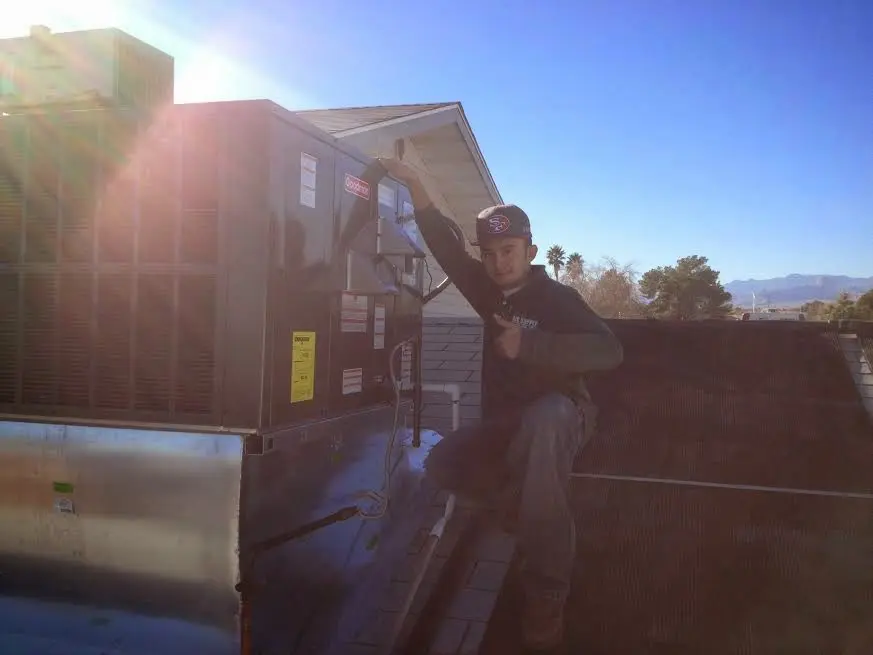 HVAC technician performing AC Tune-Up on a rooftop unit in Jerome